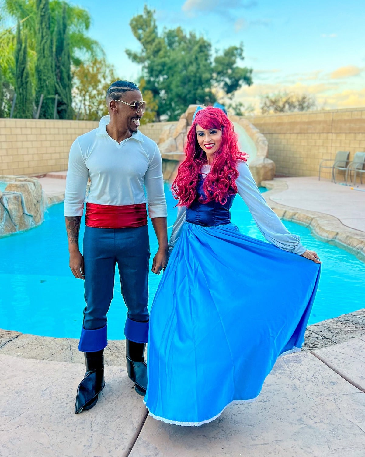 Couple in Prince Eric and Ariel costumes by a pool