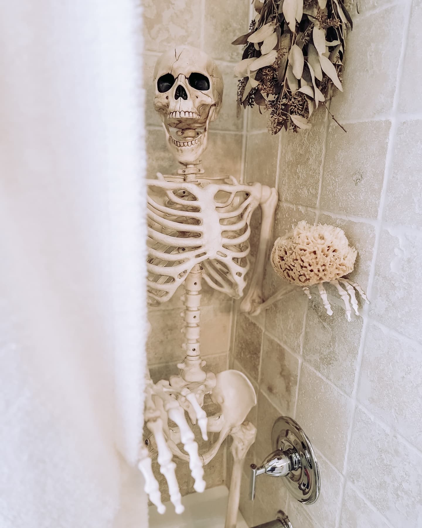 Skeleton peeking through a shower curtain