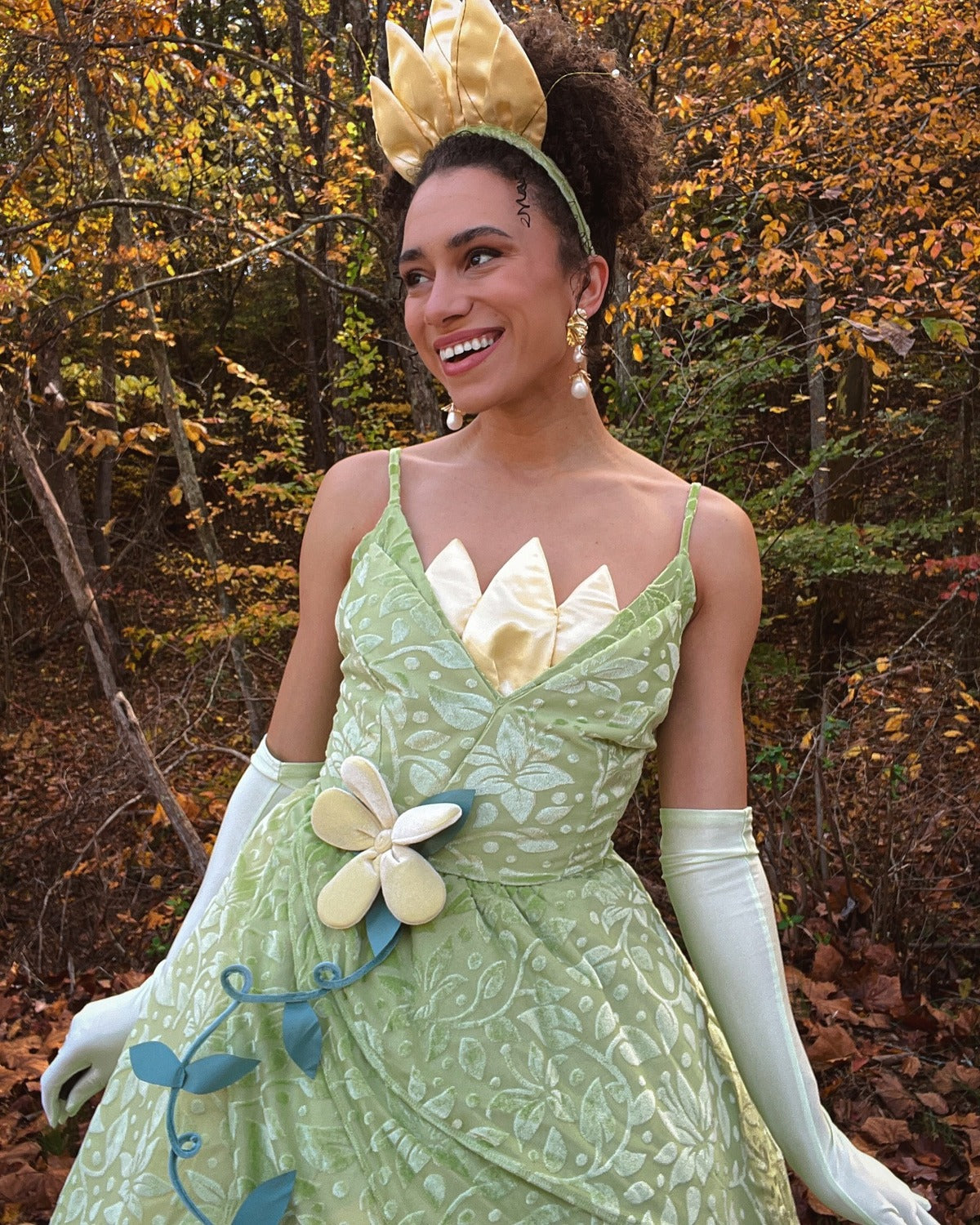 Woman wearing Tiana’s green princess dress in the woods